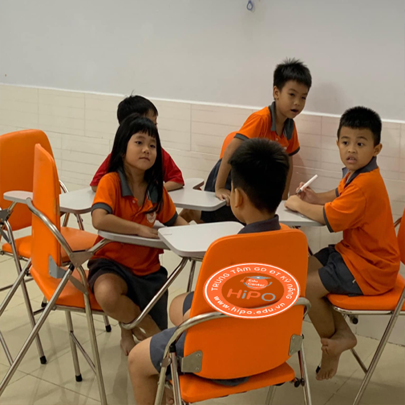 Một học sinh đang ngồi học bài với sách vở và máy tính, thể hiện sự tập trung trong việc rèn luyện thói quen học chủ động.