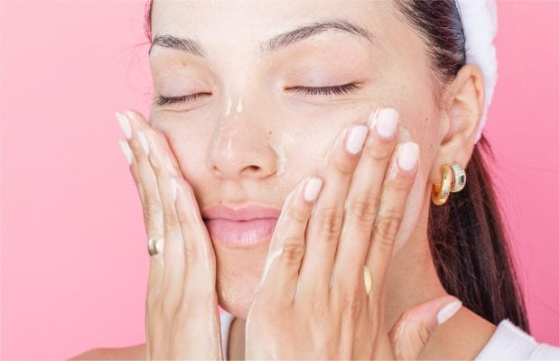 Người phụ nữ đang nhẹ nhàng thoa kem dưỡng phục hồi lên da mặt sau liệu trình treatment