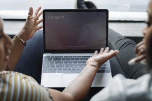 A professional reviewing AI-generated content on a laptop.