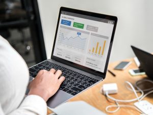 A professional reviewing a detailed content performance dashboard on a laptop screen.
