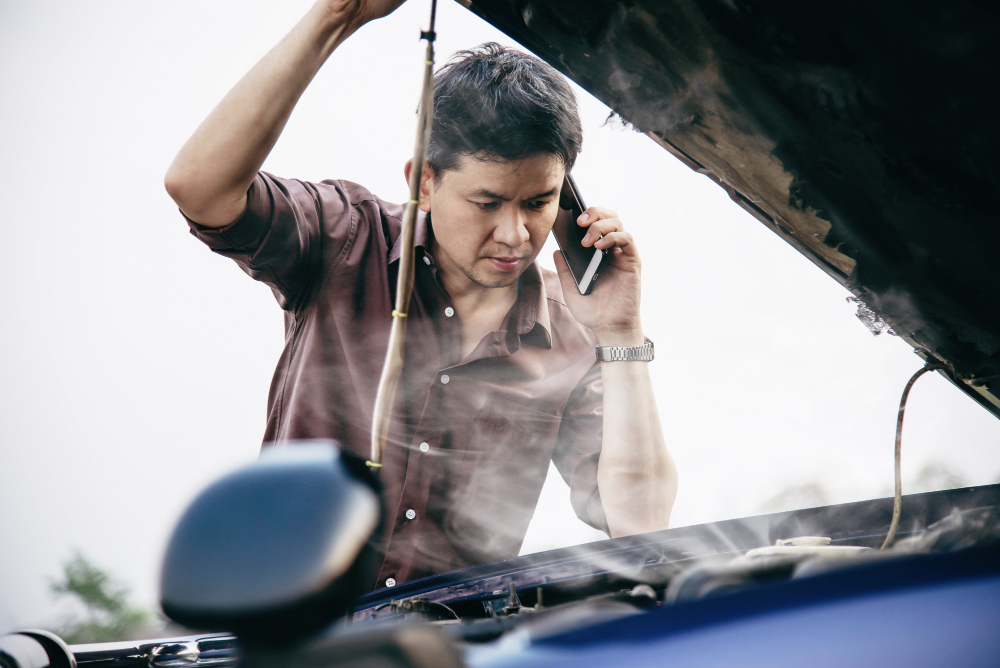 Kỹ thuật viên đang che chắn các bộ phận điện tử quan trọng trong khoang máy ô tô trước khi vệ sinh