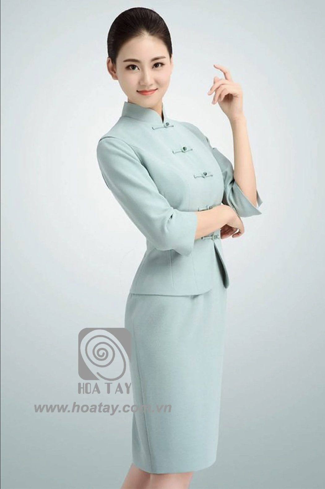 Một nữ nhân viên mặc đồng phục màu xanh bạc hà thiết kế cổ tàu, thể hiện sự tinh tế và chuyên nghiệp
