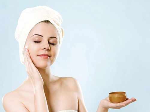 Phụ nữ thoa kem dưỡng ẩm lên vùng má, minh họa cách chăm sóc da hỗn hợp theo từng vùng cụ thể