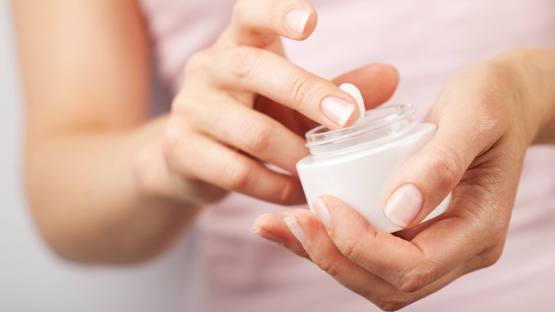 Người phụ nữ đang thoa kem dưỡng ẩm dịu nhẹ giúp phục hồi hàng rào bảo vệ da nhạy cảm
