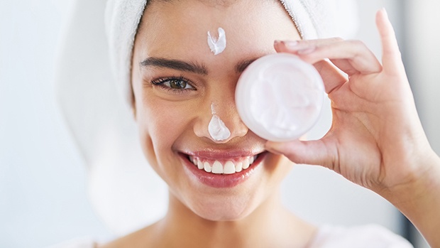 Người phụ nữ đang thoa kem dưỡng ẩm, bổ sung dưỡng chất giúp phục hồi hàng rào bảo vệ da.