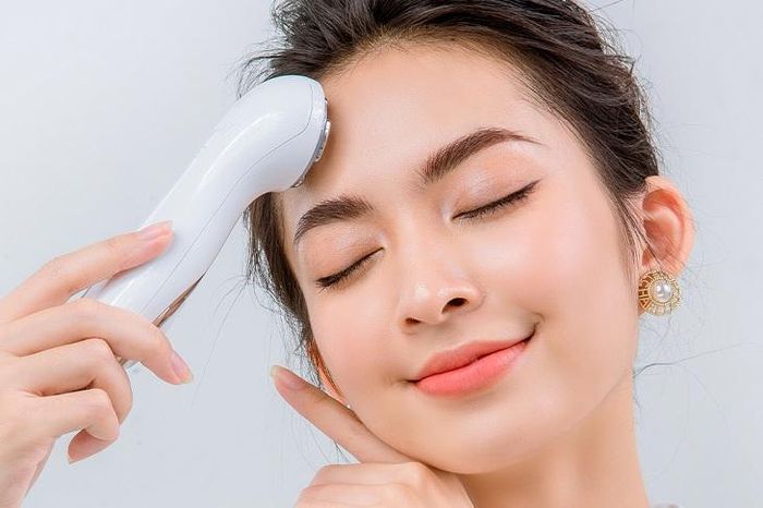 Người phụ nữ soi gương kiểm tra tình trạng da mặt để điều chỉnh routine chăm da phù hợp