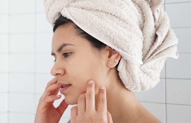 Người phụ nữ lo lắng chạm vào làn da bị kích ứng do treatment
