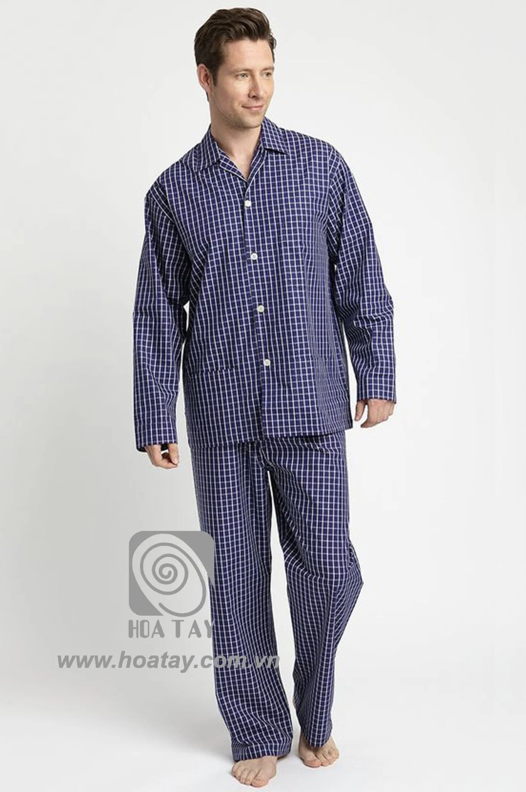 Một nam giới mặc bộ đồ ngủ kẻ ô vuông, chất liệu cotton mềm mại, phom dáng rộng rãi