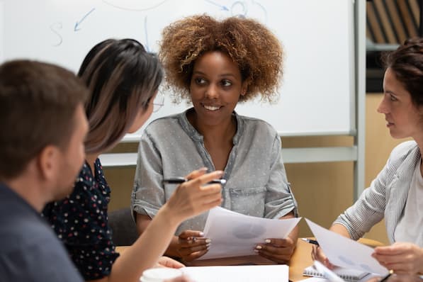 A leader mentoring and guiding employees in a collaborative setting
