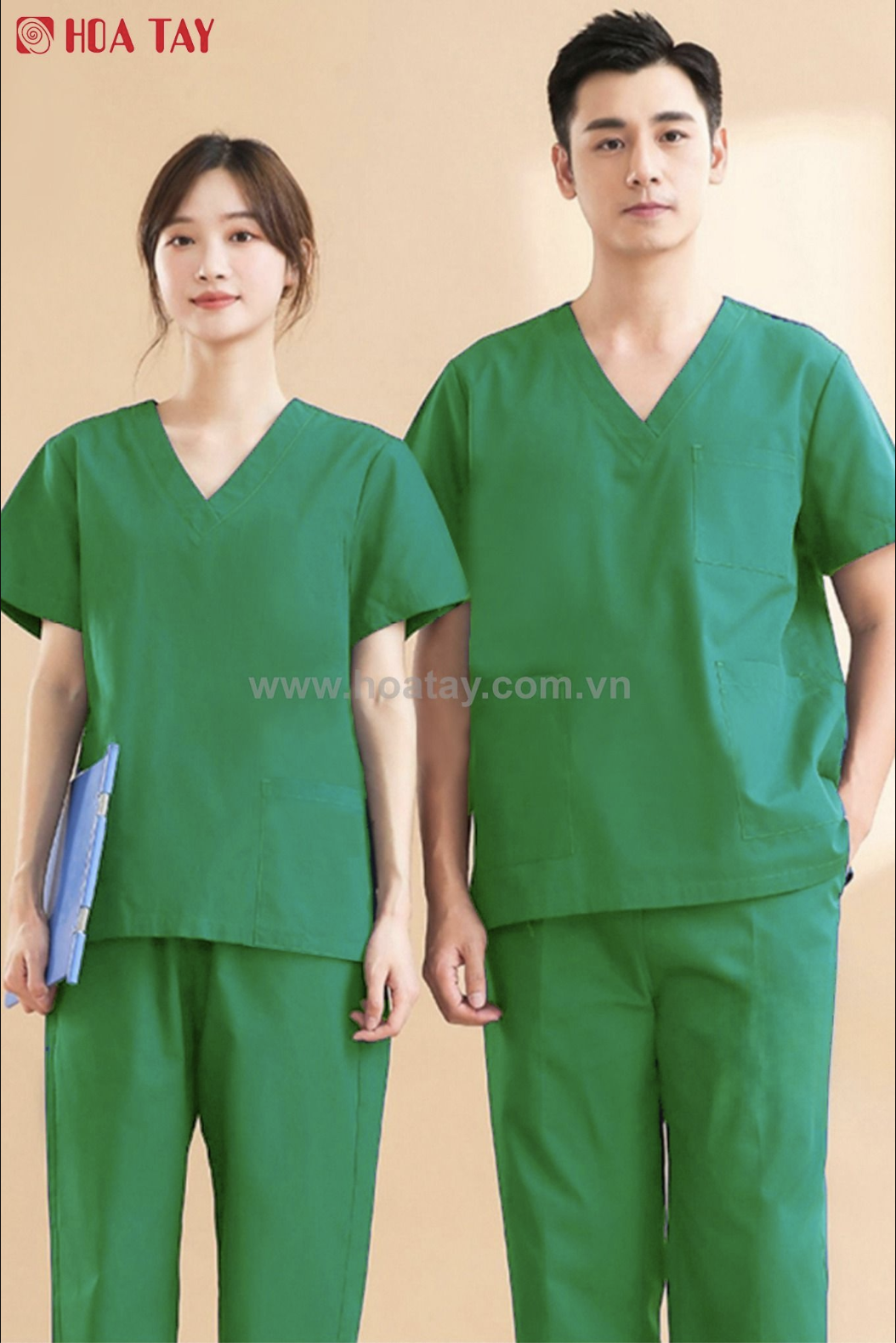 Hai nhân viên y tế (một nam, một nữ) đang đứng thẳng, mặc bộ đồ phẫu thuật (scrubs) màu xanh lá cây, cổ chữ V, tay ngắn, chất liệu vải trơn, phông nền studio sáng màu.