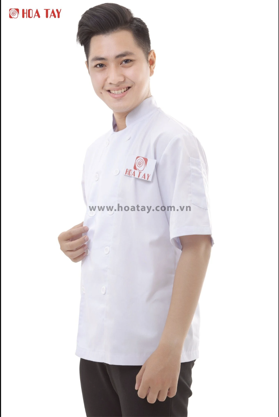 Một nam đầu bếp đang đứng, mặc áo khoác trắng tay ngắn, kiểu cổ tàu (mandarin collar), cài khuy đôi (hai hàng nút), vải cotton trơn, logo thêu đỏ trên ngực trái, nền trắng studio ánh sáng đều.