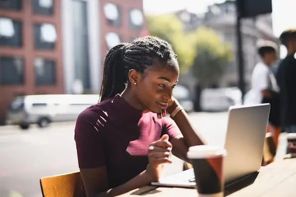 blogger naming her new blog using her laptop and drinking coffee