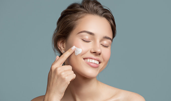 Người phụ nữ đang thoa kem phục hồi da một cách cẩn trọng