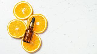 Hình ảnh minh họa serum Vitamin C trên lát cam, tượng trưng cho khả năng hấp thụ hoạt chất của da
