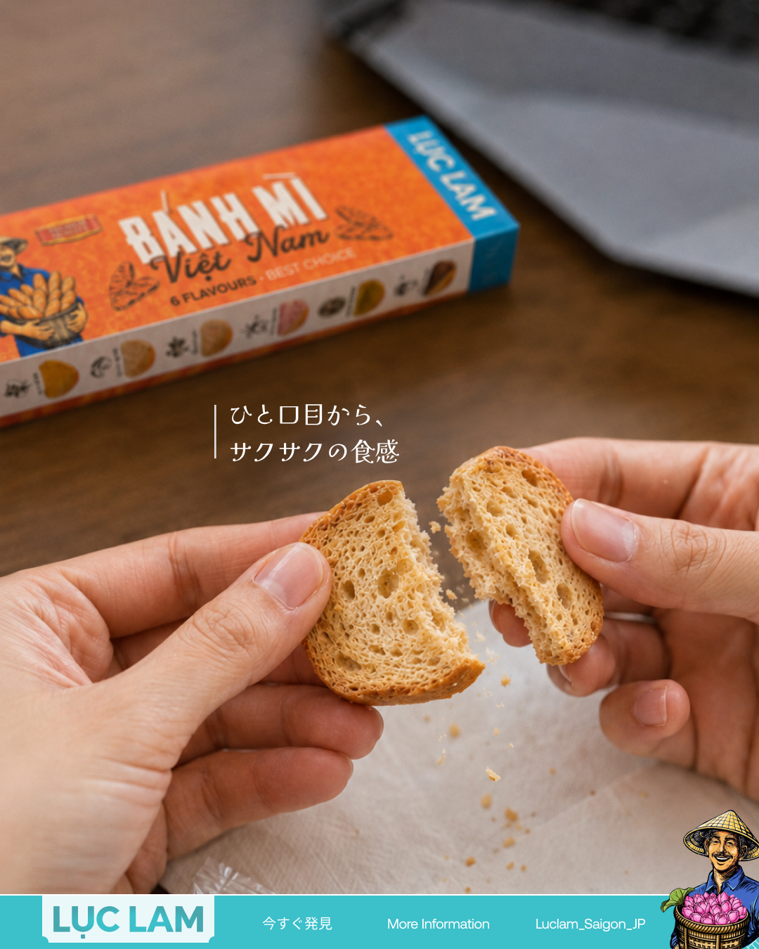 Two hands breaking a small, golden-brown bread roll in half, revealing a porous, airy crumb structure. In the background, an orange and blue box labeled 'Bánh Mì Việt Nam' sits on a wooden table. Japa