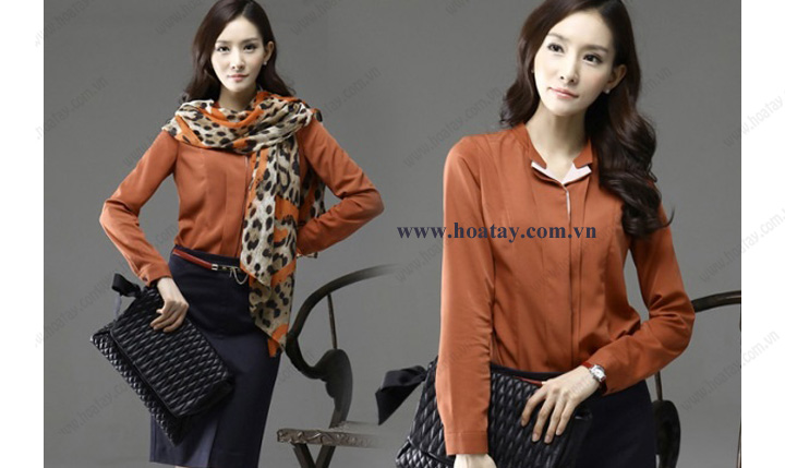 Hai nhân viên y tế (một nam, một nữ) đang đứng, mặc áo blouse trắng (áo khoác bác sĩ) cổ bẻ, tay áo bo chun (cổ tay co giãn), chất liệu vải phẳng, bên trong là bộ scrub xanh ngọc, bối cảnh studio với