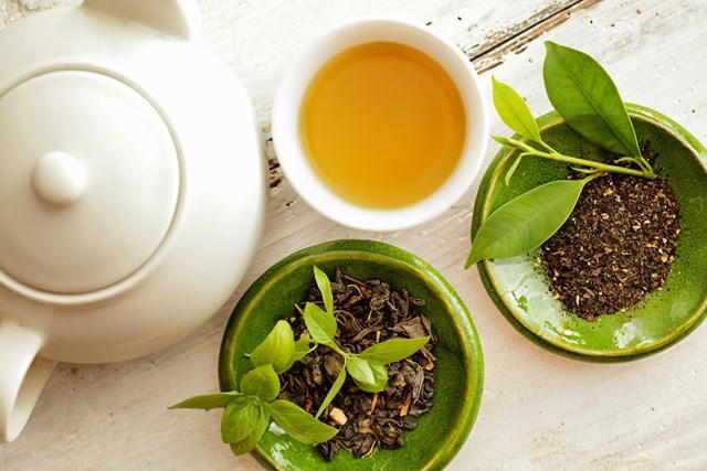 Cánh hoa trà thảo mộc tự nhiên nở rộ trong tách thủy tinh, giữ trọn dưỡng chất hỗ trợ làm đẹp da.
