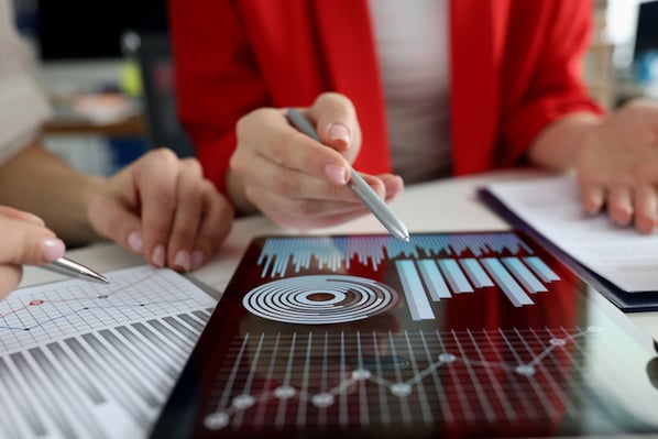 A team of professionals analyzing data dashboards on multiple monitors