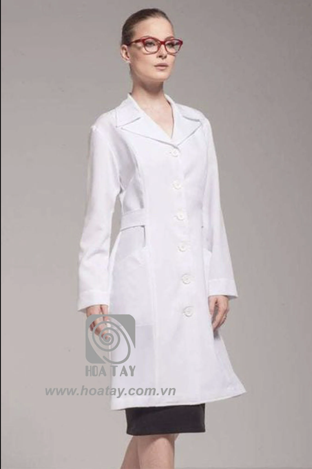 Một nữ bác sĩ mặc áo blouse trắng (áo khoác phòng thí nghiệm) dài tay, cổ bẻ (cổ ve), cài khuy dọc thân, chất liệu vải cotton phẳng phiu, phom dáng chiết eo, nền xám, ánh sáng studio chuyên nghiệp.