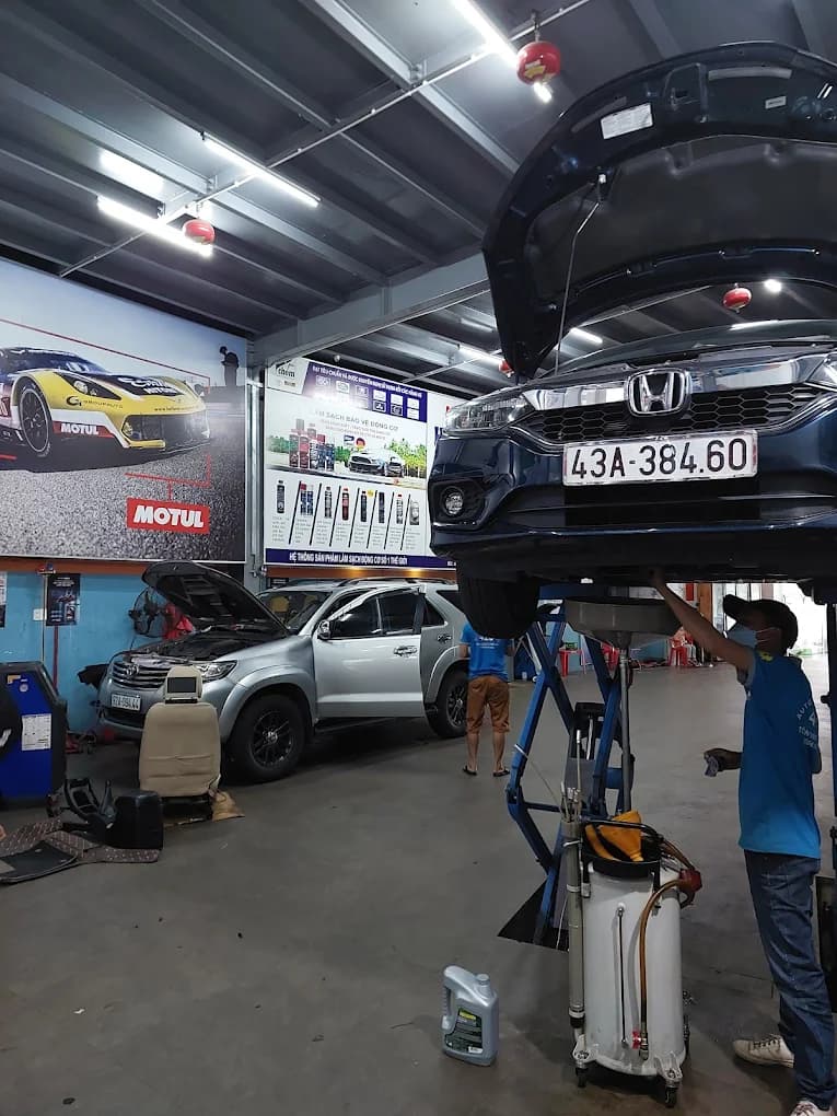 Kỹ thuật viên tại garage kiểm tra lốp xe và hệ thống lái để cân chỉnh thước lái chính xác.