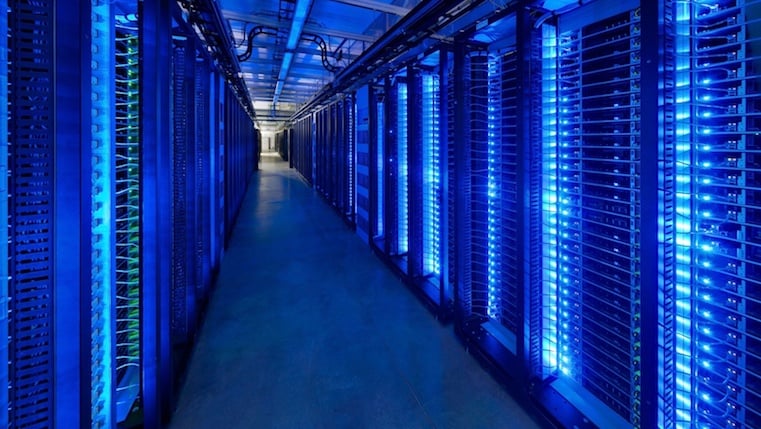 A server room with dark lighting and rows of equipment