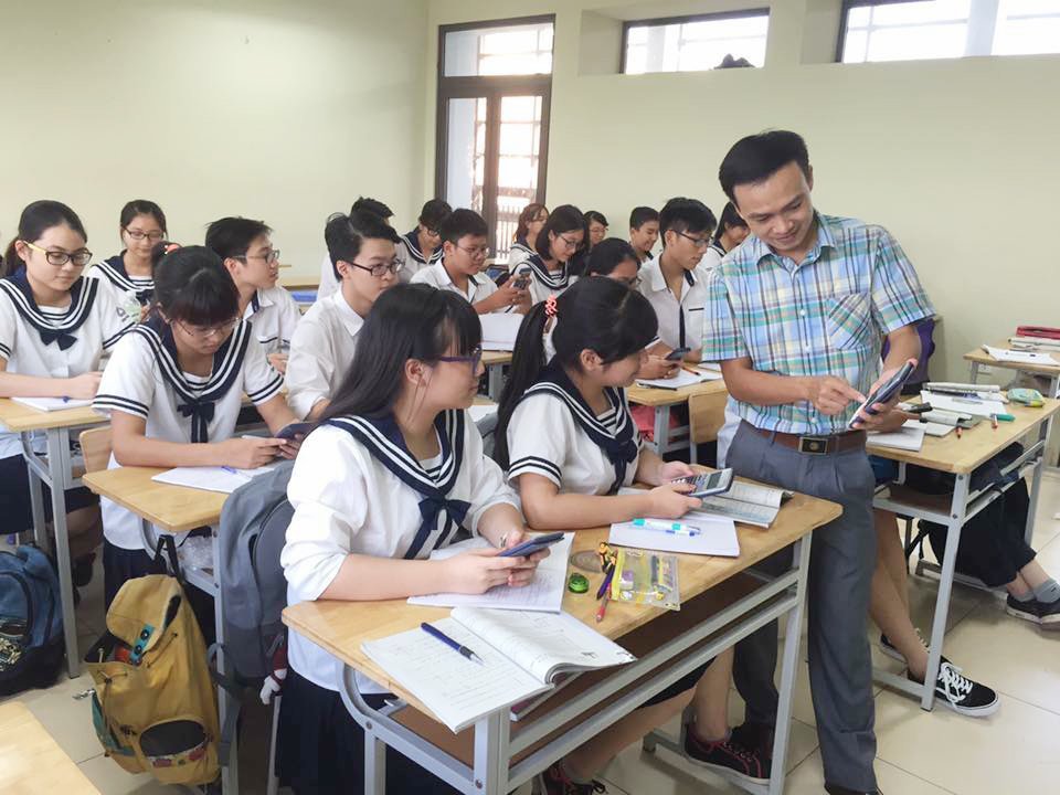 Học sinh trao đổi bài với giáo viên, thể hiện sự tương tác và hỗ trợ trong môi trường học tập hiệu quả