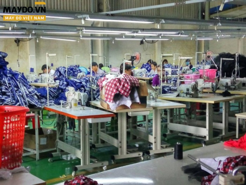 Nhân viên QC kiểm tra chất lượng sản phẩm đồng phục tại xưởng để đảm bảo tiến độ