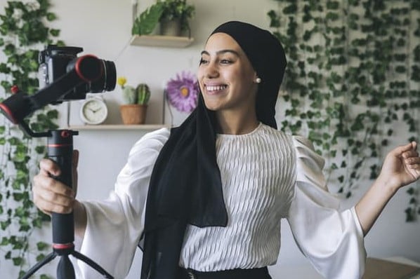 A woman films a video as part of the creator economy.